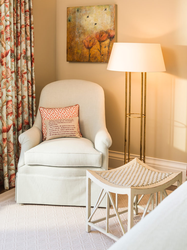 Light-colored plush armchair in the corner of a bedroom