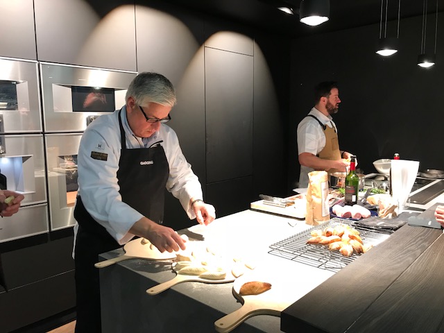2 men at a design show preparing food