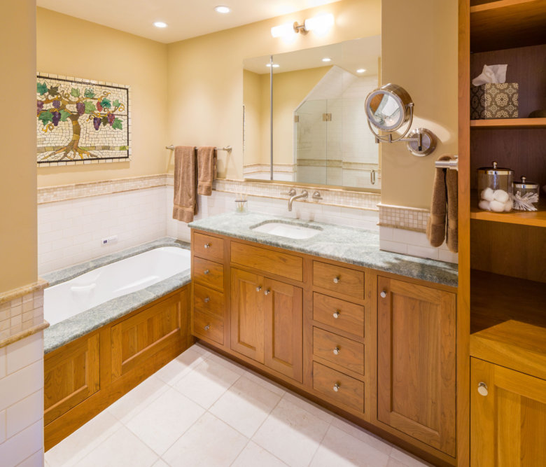 well-lit bathroom with a large mirror, stone countertops and lots of wood finishing