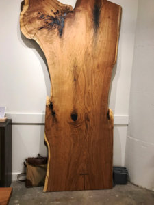 large piece of live edge wood leaning against a wall
